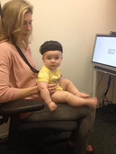 A BABY WEARS A NEAR INFRARED SPECTROSCOPY-SENSING HEADBAND IN THE LAB OF BROWN UNIVERSITY ASSOCIATE PROFESSOR DIMA AMSO
